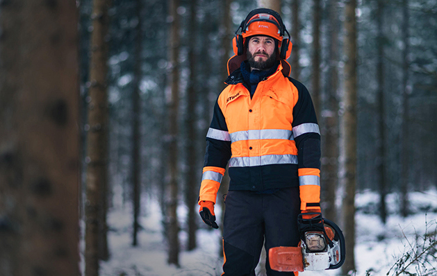 Metsuri kävelee moottorisahalla talvisessa metsässä